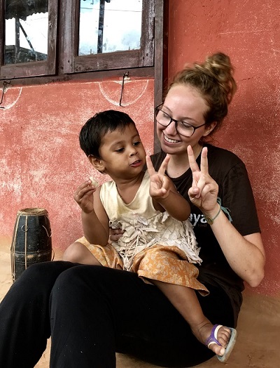 Global Service Scholar Jordan Stead spends time with a child in Nepal in 2018.